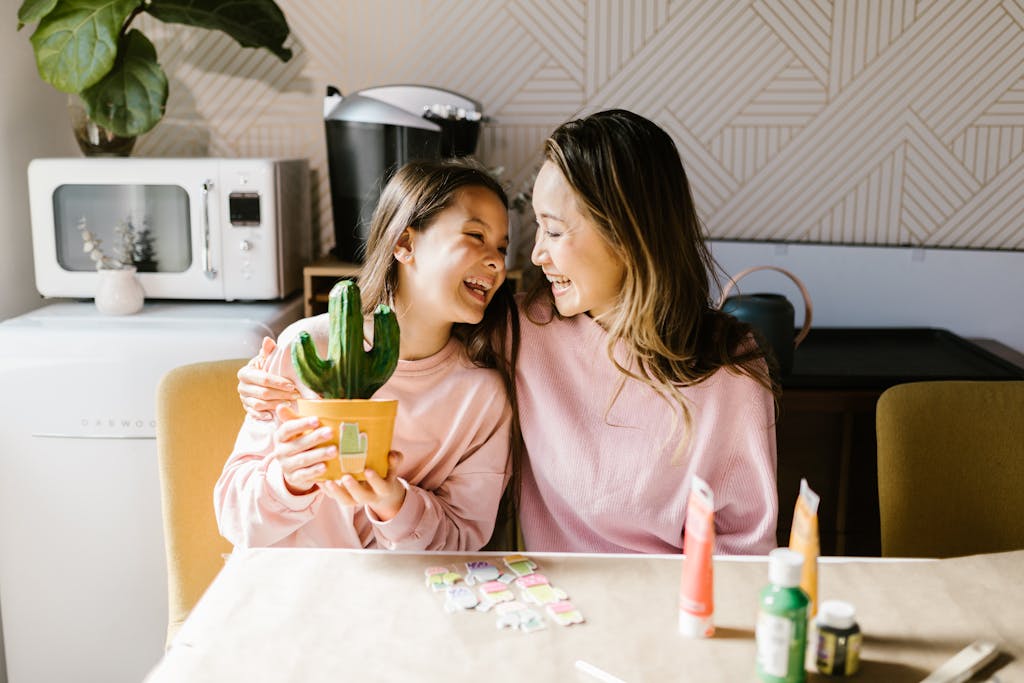 A joyful moment at home as a mother and daughter engage in arts and crafts together.